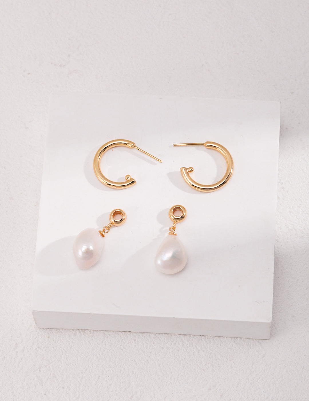 Gold hoop earrings with detachable baroque pearls charms.