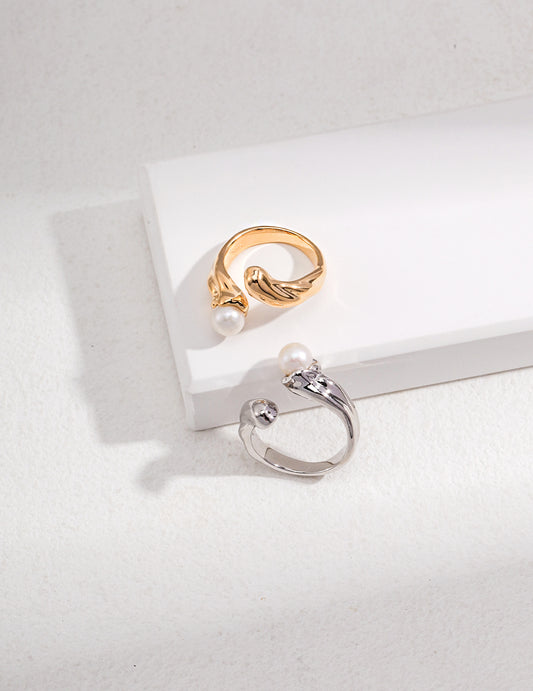 Two elegant rings with lustrous freshwater pearls, one in silver and the other in gold.