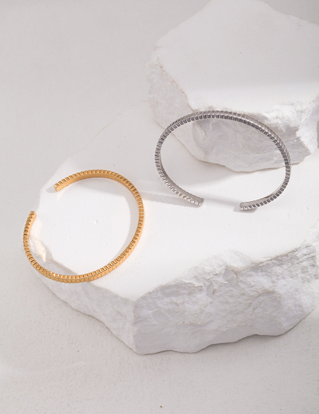 Stylish gold and silver bangles displayed on a white background.