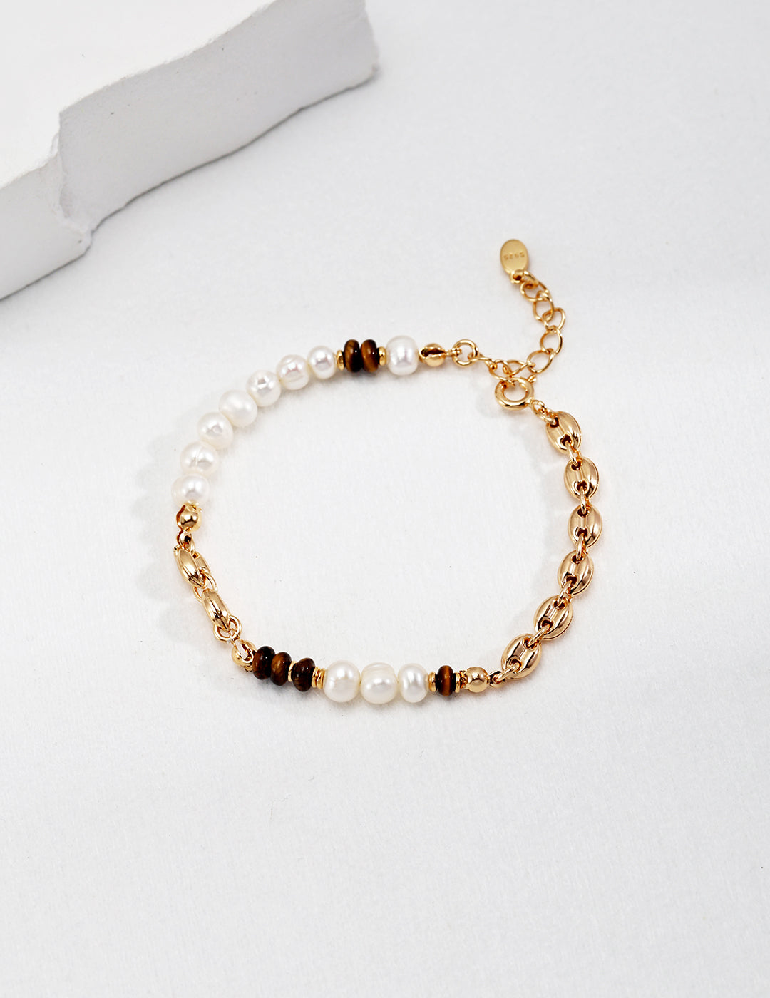 Gold and white pearls bracelet, adorned with tiger's eye beads, a stunning accessory that adds elegance and sophistication to any outfit.