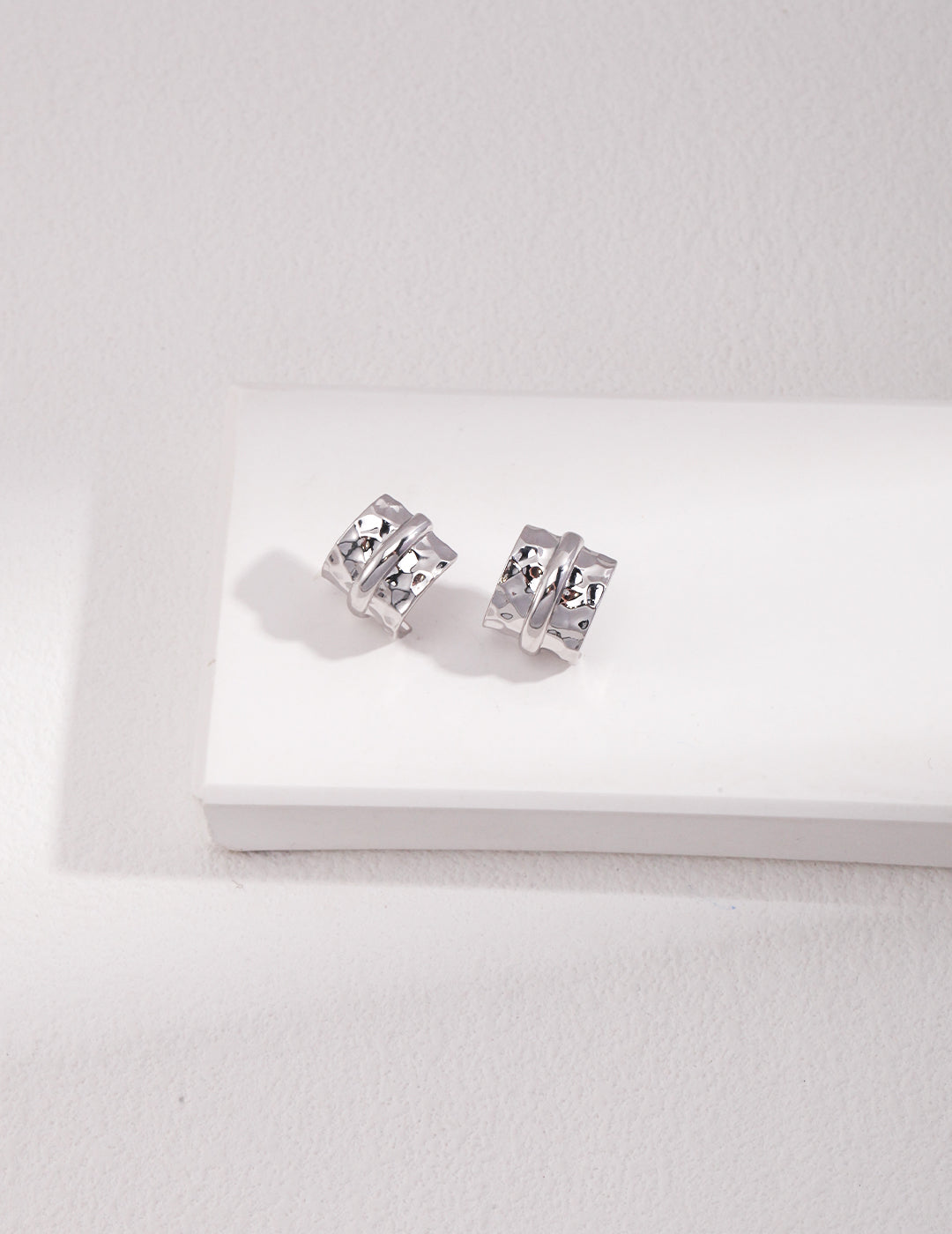 Stylish silver cuff earrings displayed on a white background