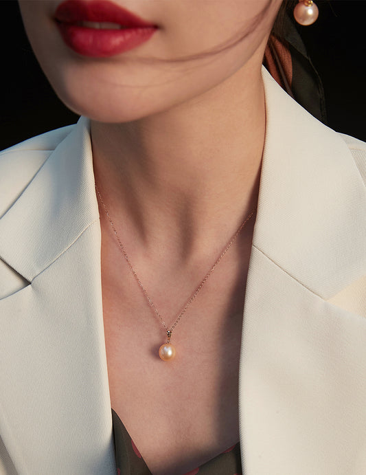 A stylish woman in a white blazer showcases a beautiful rose gold freshwater pearl necklace, radiating grace and charm.