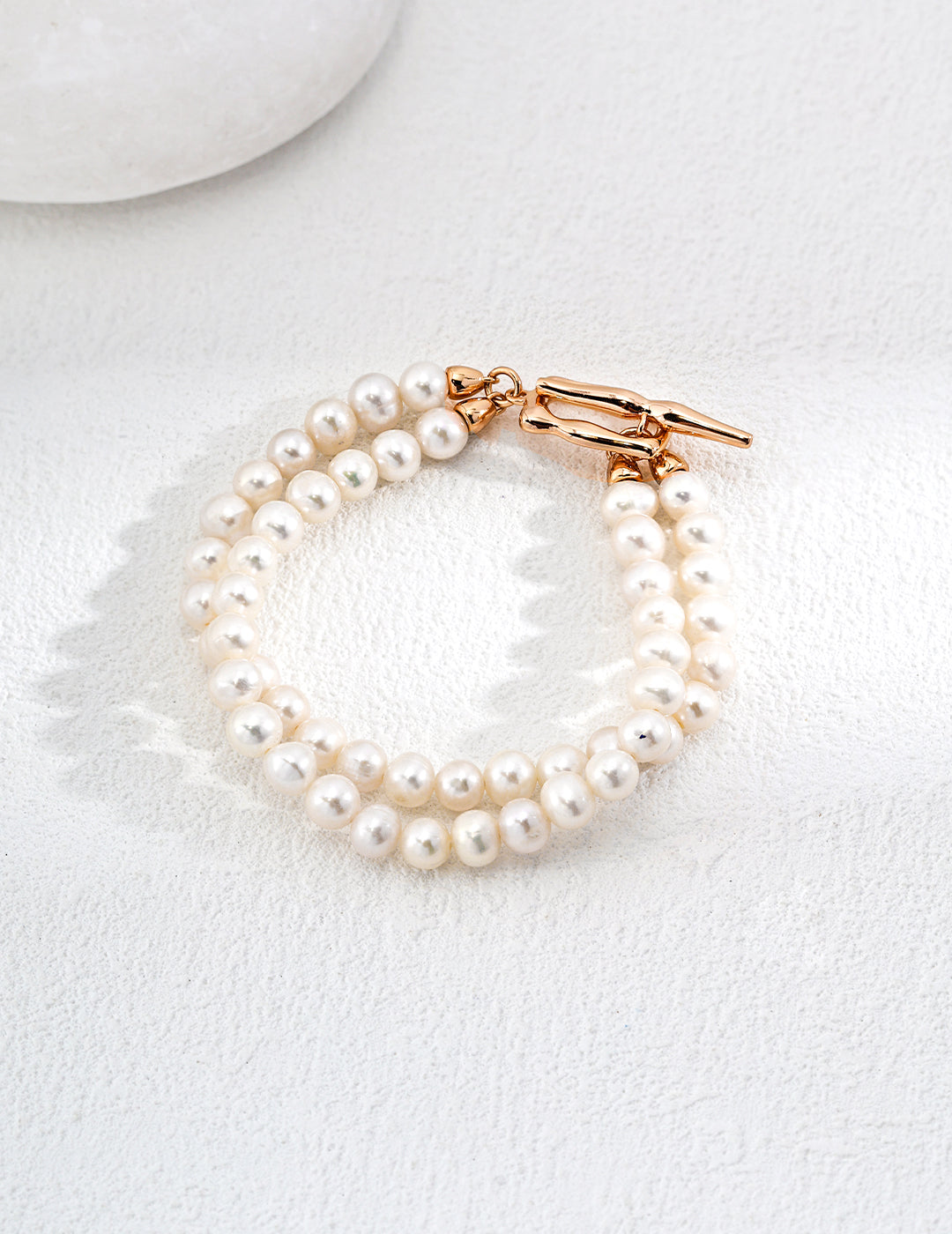 Chic duo-layer freshwater pearl bracelet adorned with a gold clasp and a white stone, perfect for any occasion.