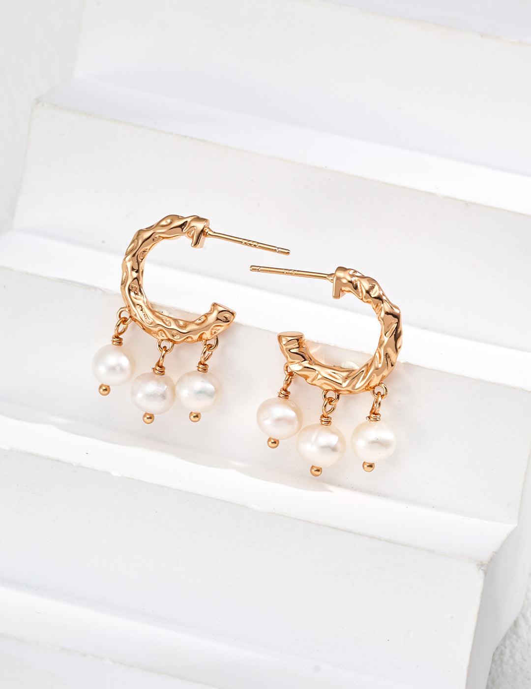 Chic gold hoop earrings embellished with pearls, offering a timeless accessory for a fashionable look.