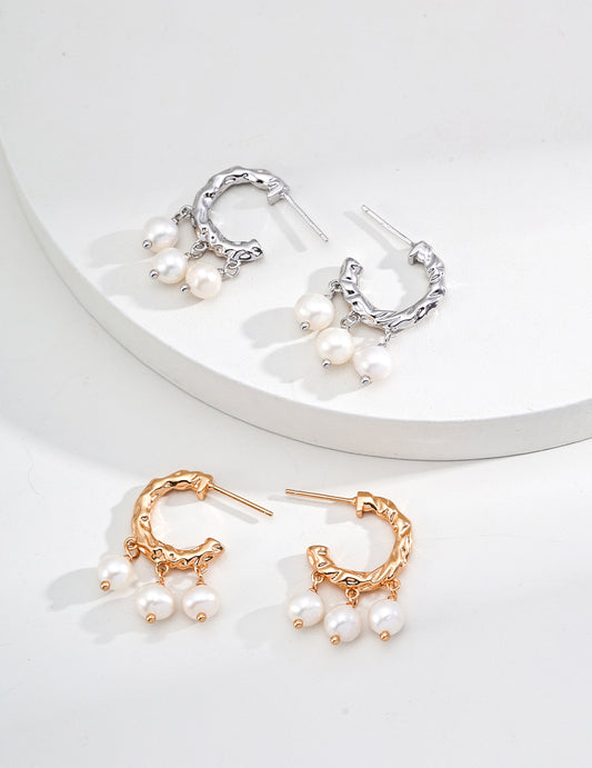 Elegant gold and white pearl hoop earrings, featuring two pairs available in both gold and silver finishes.