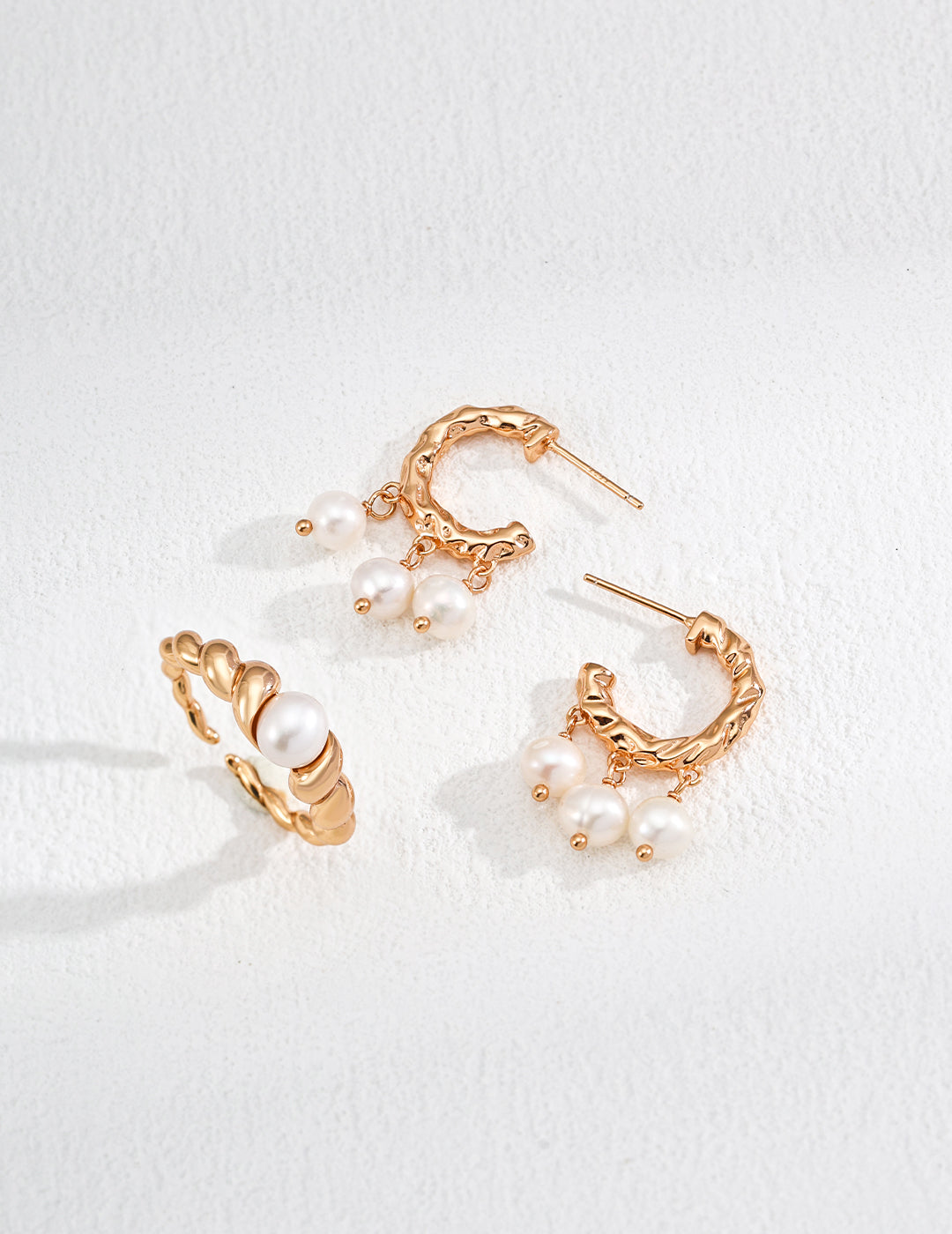 A pair of matching gold hoop earrings featuring beautiful pearls, perfect for adding a touch of elegance to any outfit.