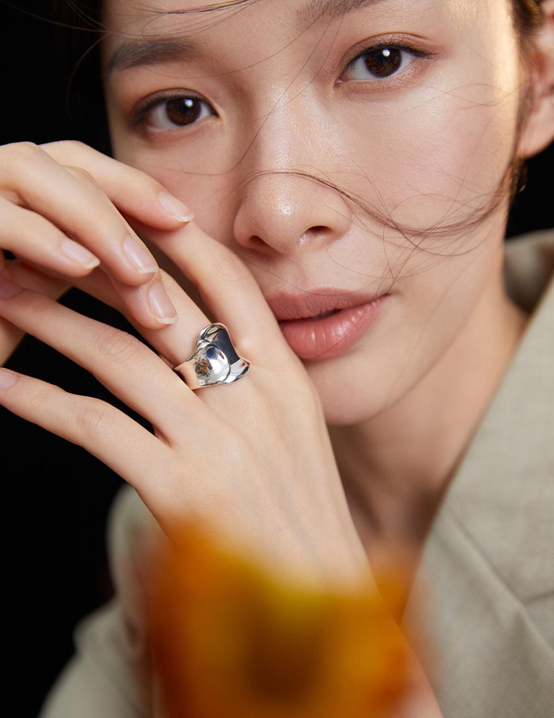 Woman wearing a silver chunky belt ring with a flower in her hand.