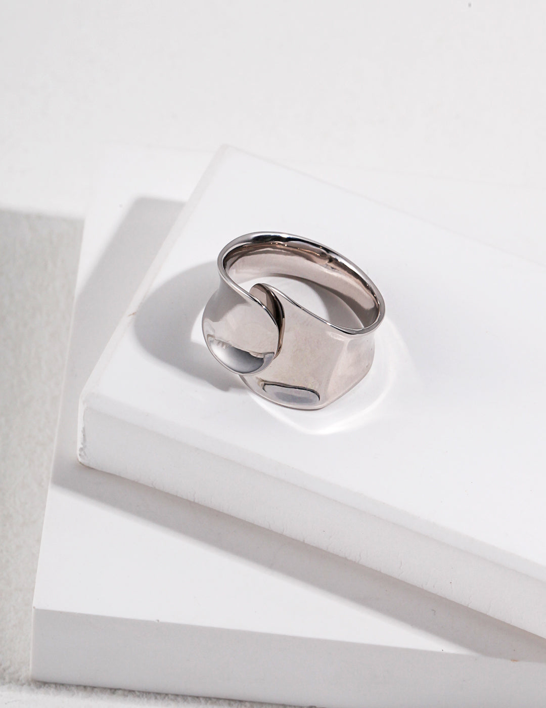 A stylish silver ring resting on a pristine white box.