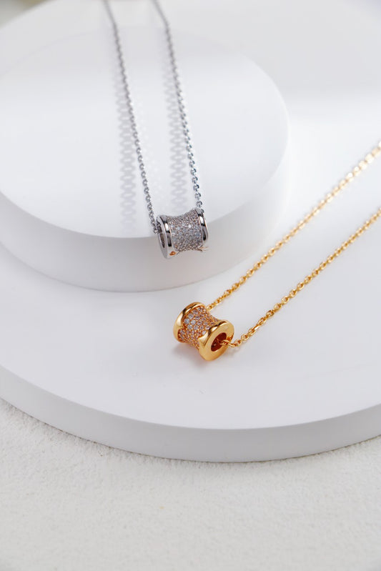 A pair of exquisite gold and silver necklaces adorned with a cubic zirconia pendant, offered in both silver and gold finishes.