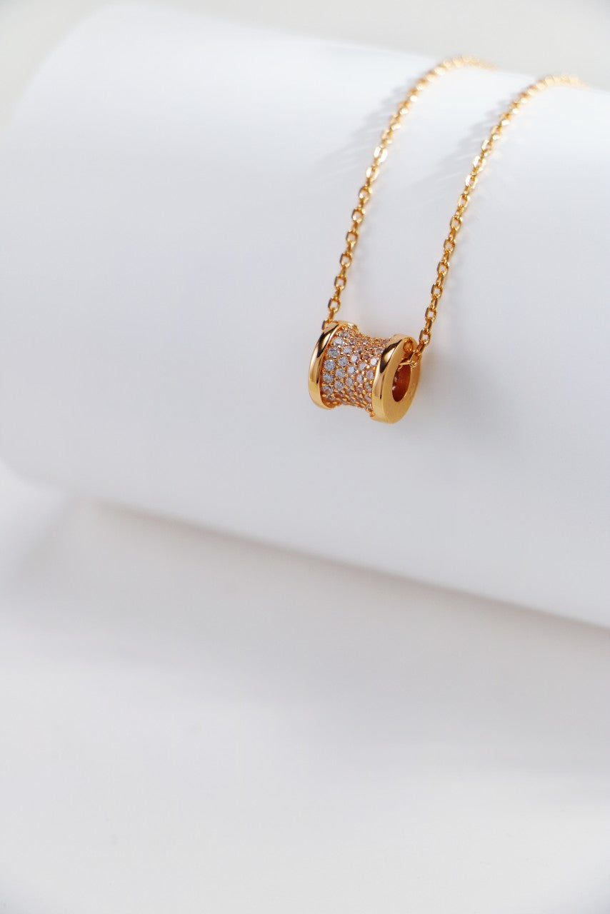 A delicate gold necklace featuring a small, sparkling diamond pendant, exuding elegance and charm.