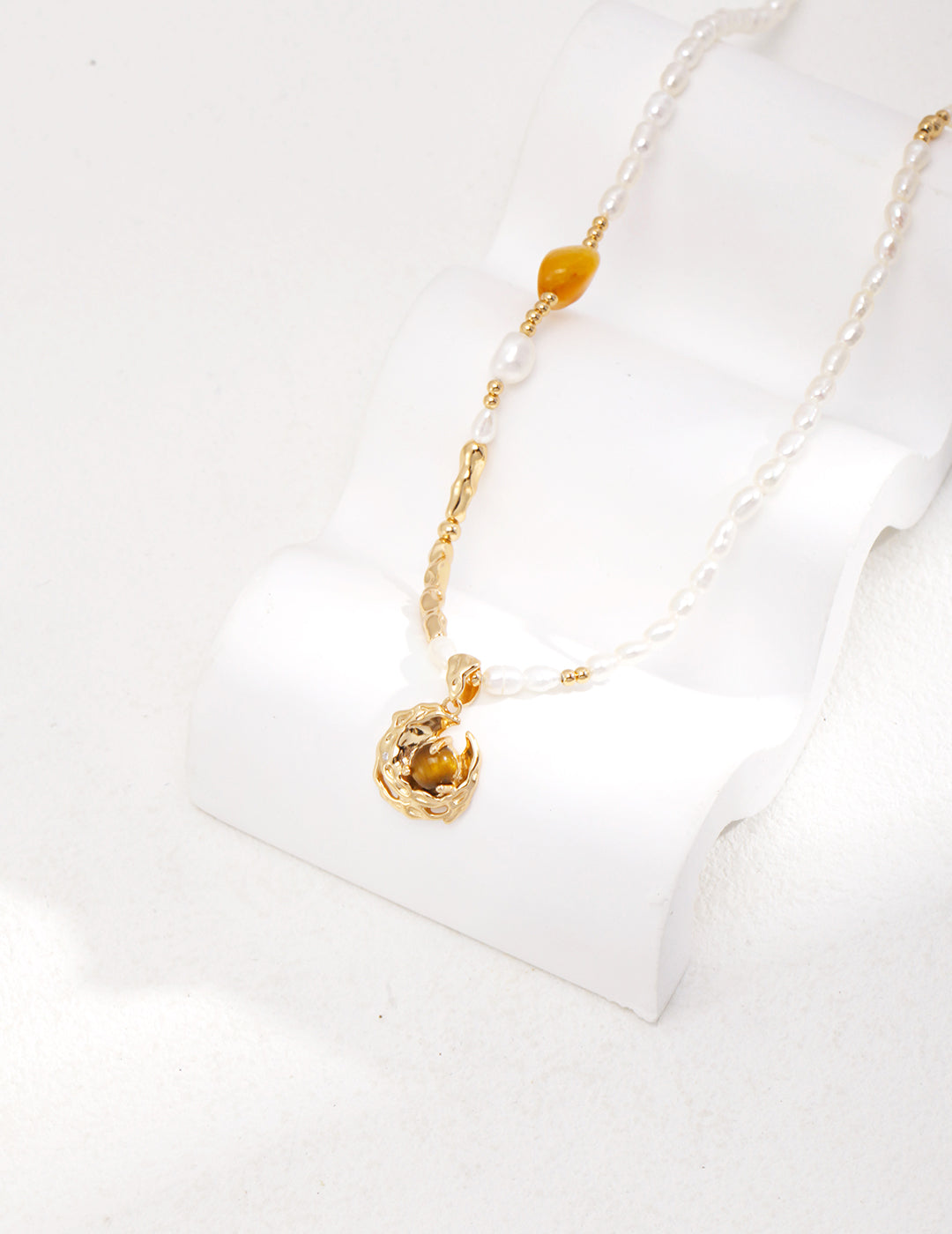 Stylish gold plated pearl necklace with tiger's eye crescent moon charm, and agate.