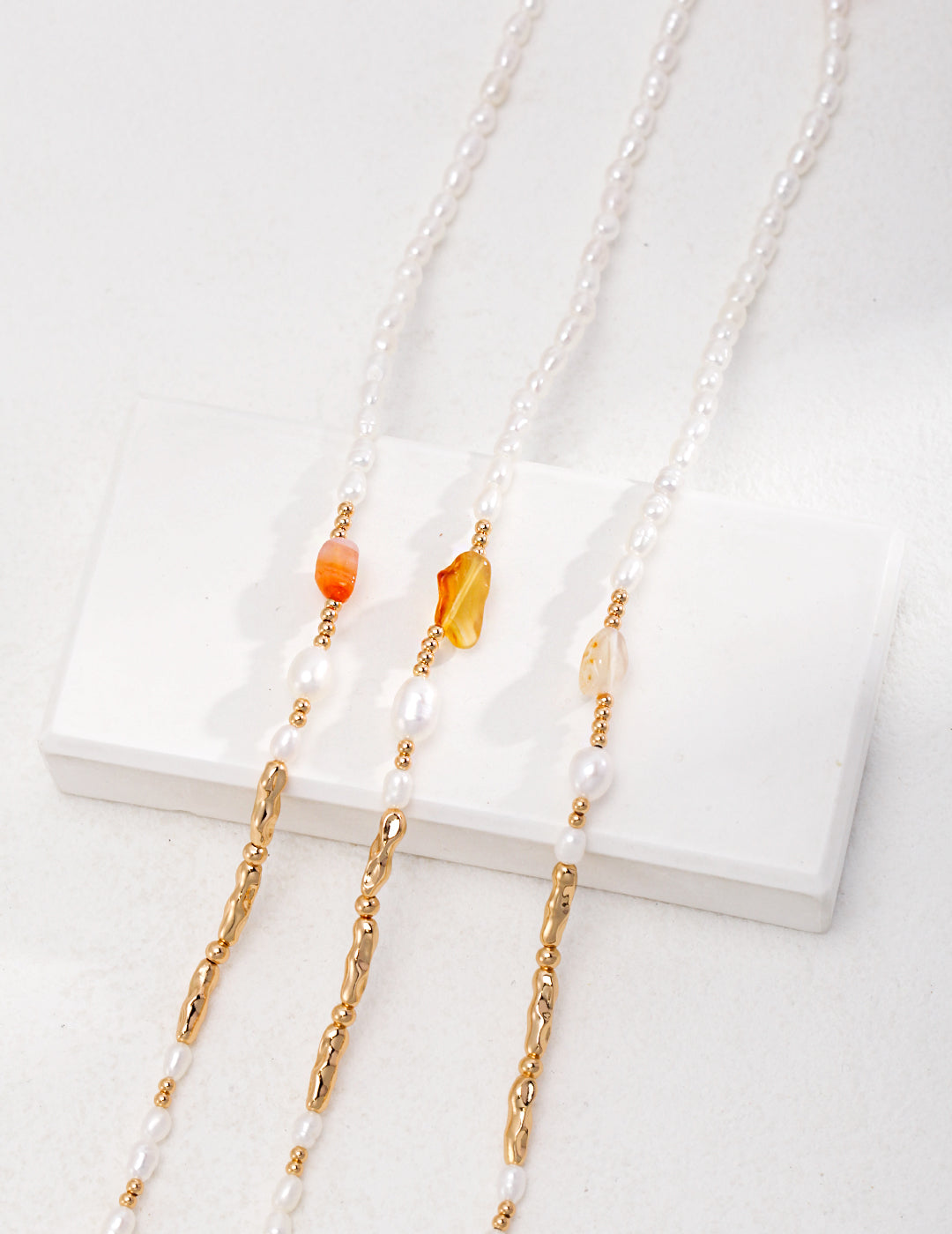 Stylish gold chain necklace with white stone and distinctive agate details.