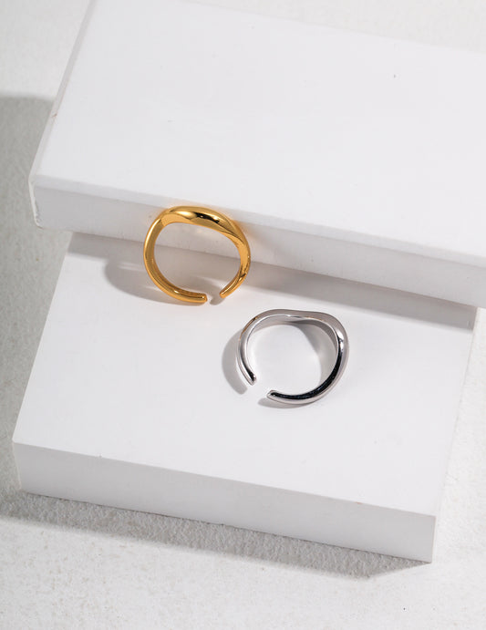 Two simple silver and gold rings resting on a white box.