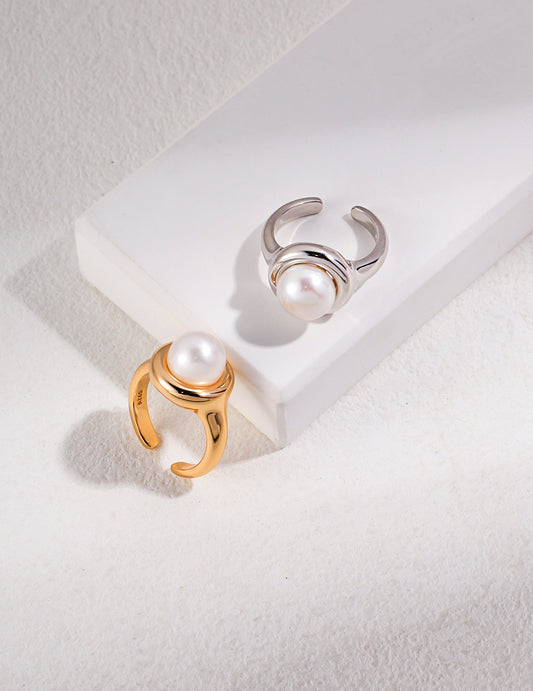 Elegant silver and gold rings featuring white freshwater pearls on white background.