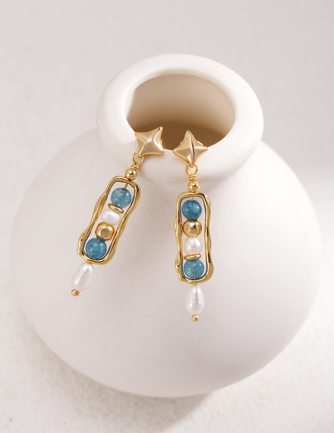 Gold dangling earrings with blue gemstones, elegant and unique.