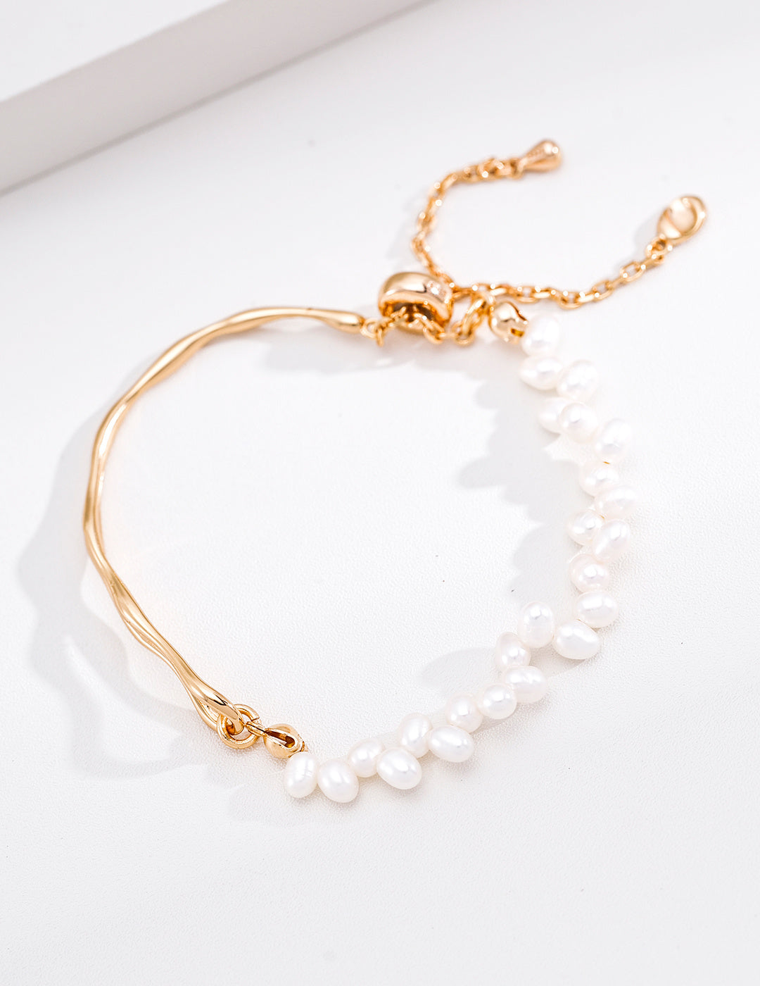 A detailed studio view of the gold vermeil Emily Bracelet, emphasizing its warm tone, adjustable sliding mechanism, and organic pearl layout.