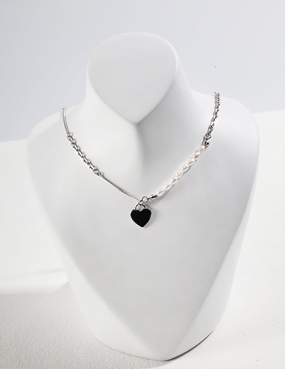 Elegant silver chain necklace, accented by silver black enamel heart pendant and freshwater pearls.