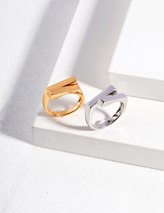 Minimalist silver and gold rings resting on white.