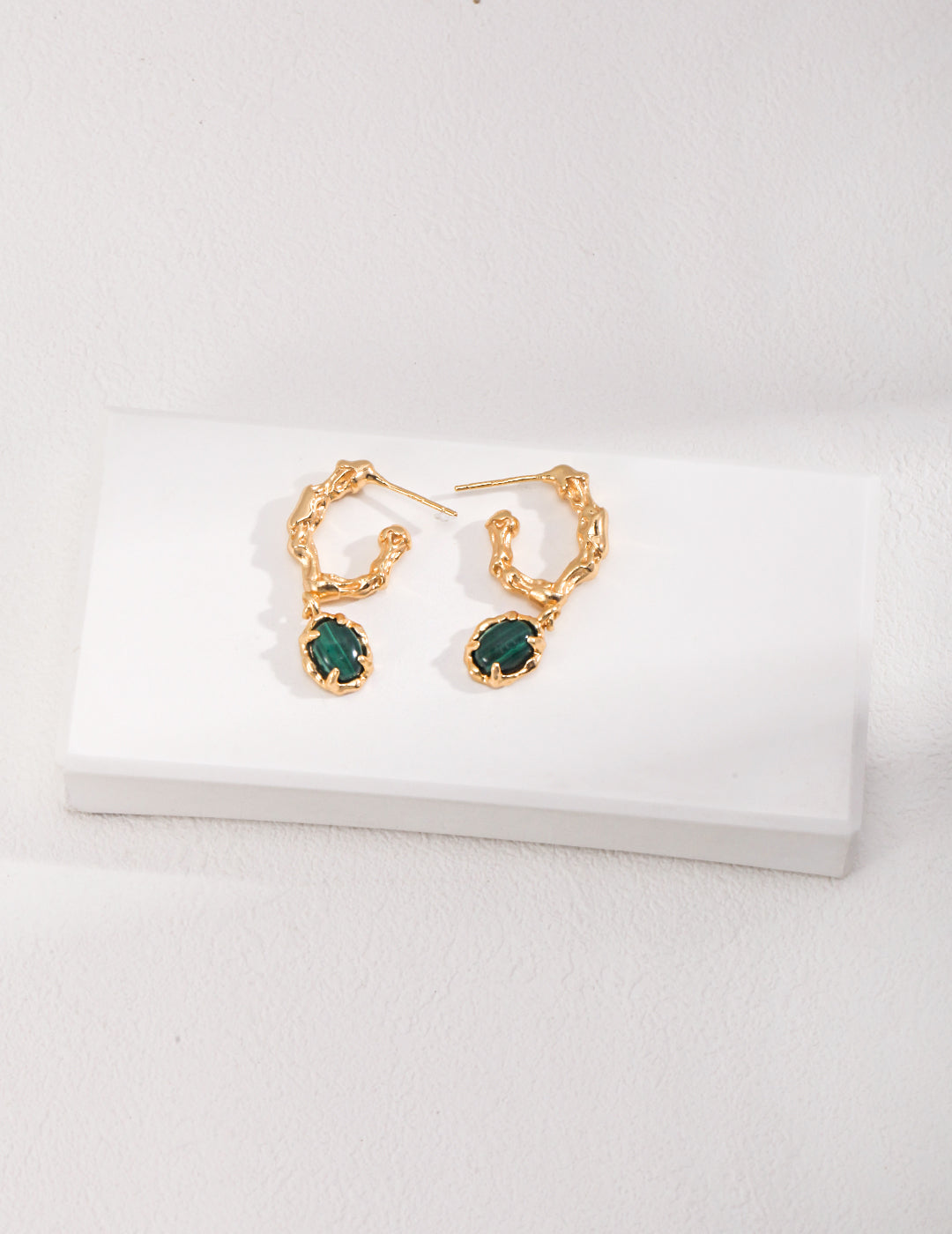 Elegant gold malachite earrings on white background.