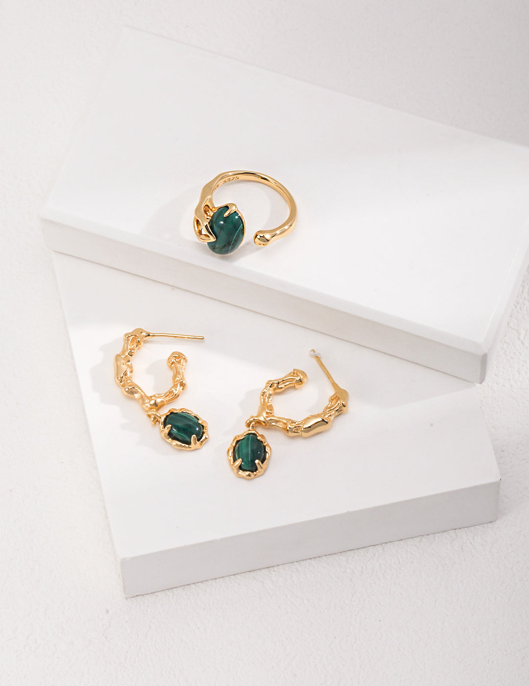 A pair of gold plated malachite earrings and a gold ring with malachite, perfect for adding a touch of elegance and style to any outfit.