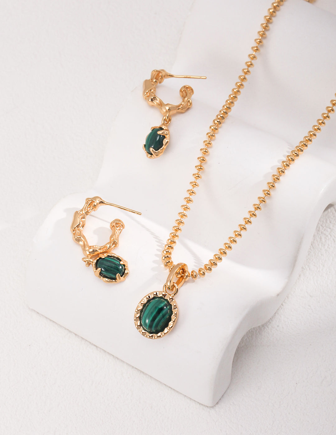 Stylish gold plated malachite set featuring a necklace and matching earrings.