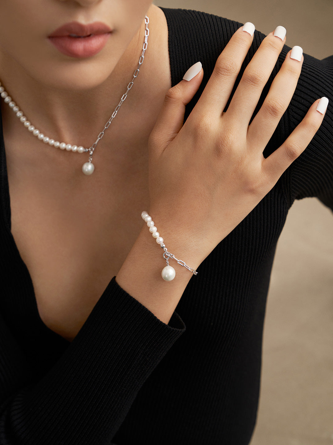 A stylish woman accessorized with a pearl necklace and bracelet.