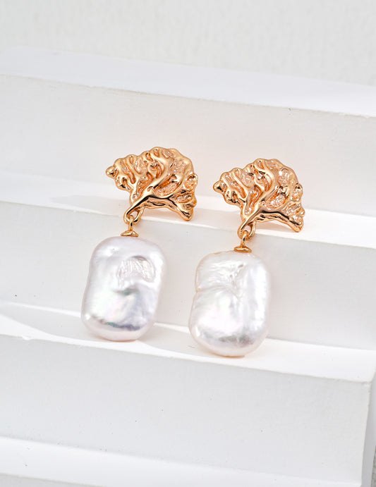 Elegant gold earrings featuring lustrous white pearls, perfect for adding a touch of sophistication to any outfit.