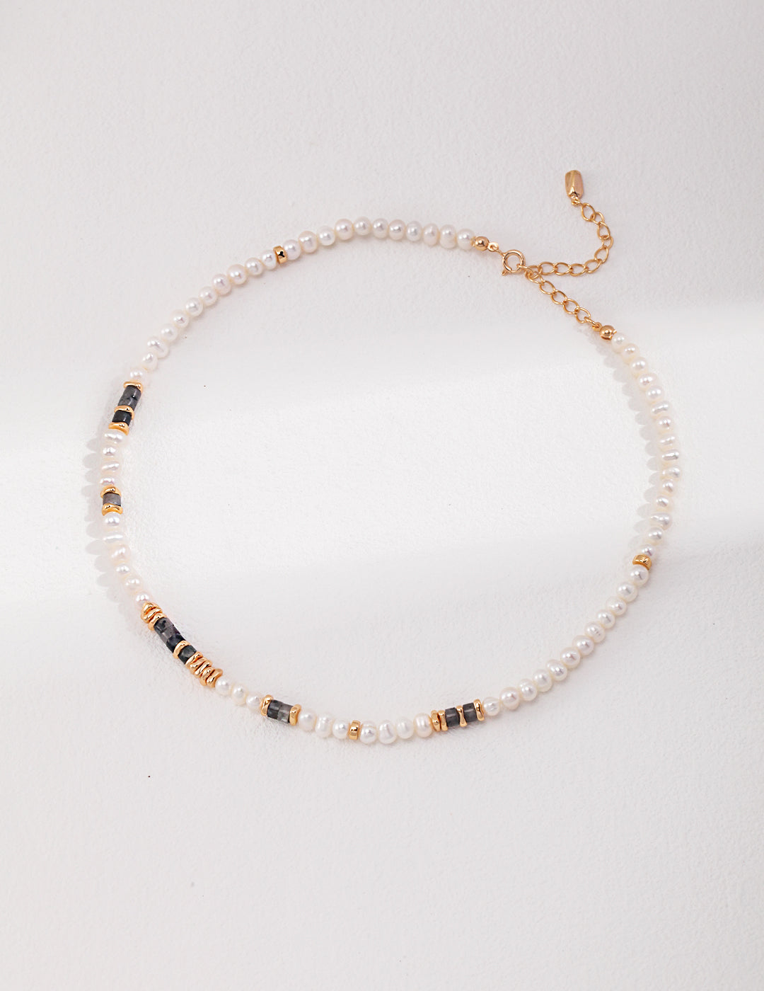 Stunning gold and pearl necklace featuring freshwater pearls and labradorite on white.