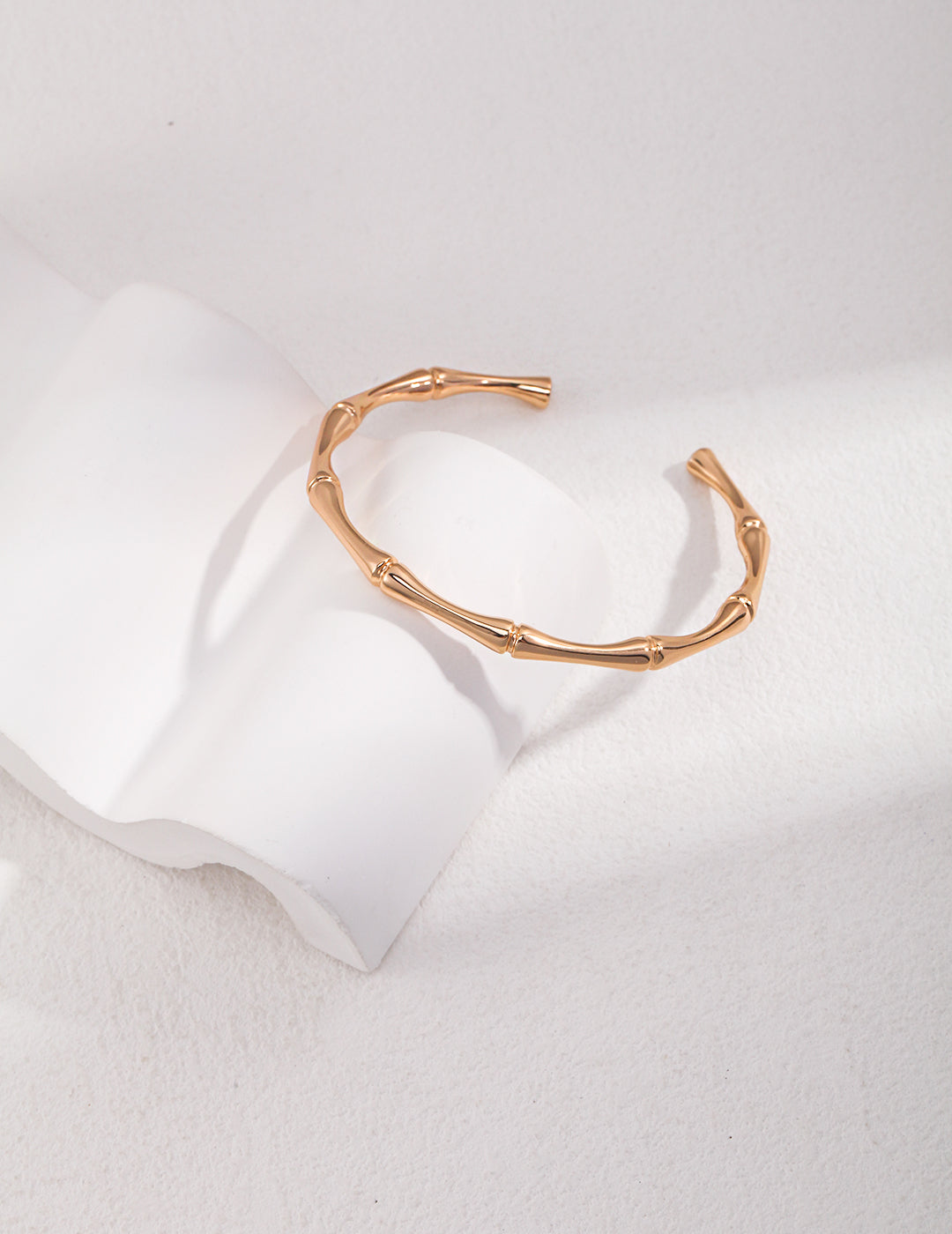 A stunning gold bangle featuring an intricate bamboo design, adding elegance and charm to your wrist.