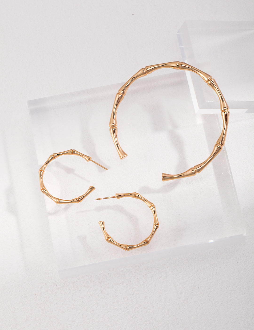 Set of gold hoop earrings and bangle bracelet with bamboo design.