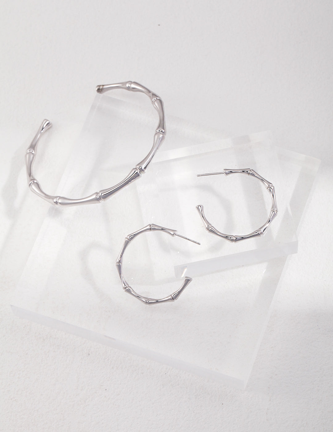 A pair of silver hoop earrings and matching bangle.