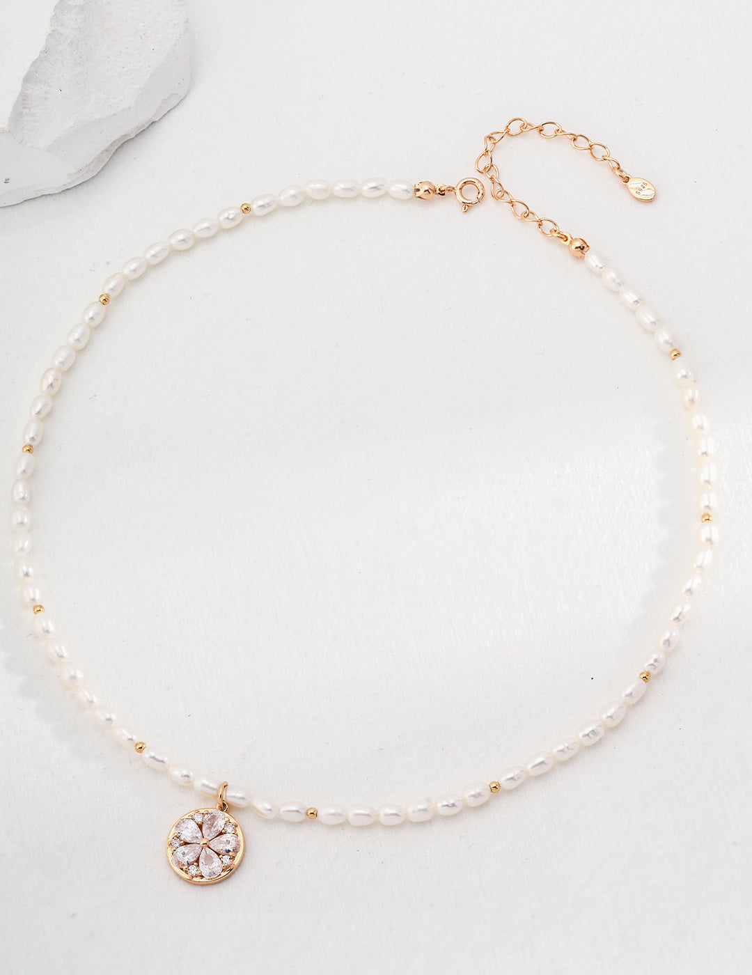 Necklace with gold plated flower pendant, adorned with pearls.