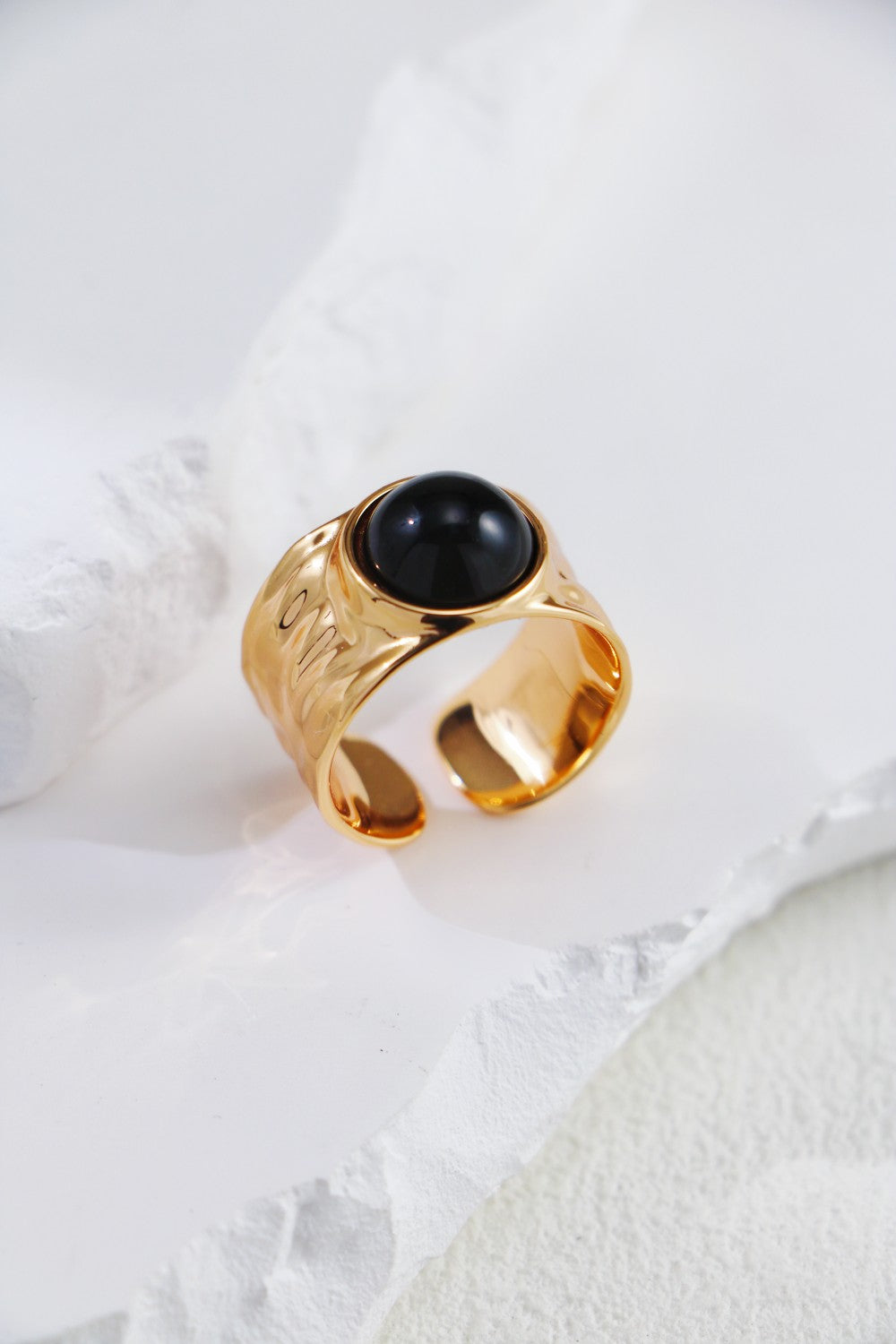 A bold gold ring featuring a striking black onyx stone, showcasing elegance and sophistication.