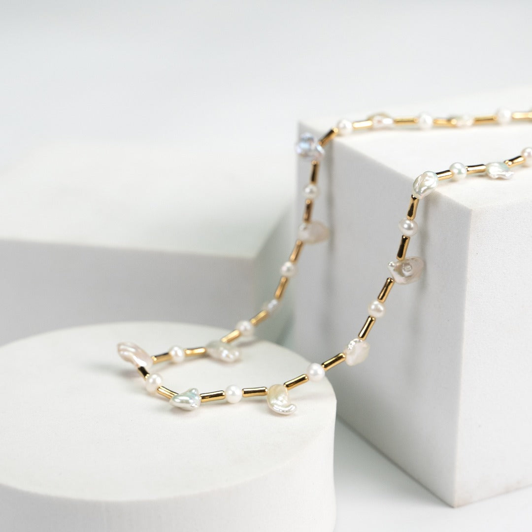 White necklace with gold beads and a blend of baroque and freshwater pearls, creating an elegant and dreamy aesthetic.