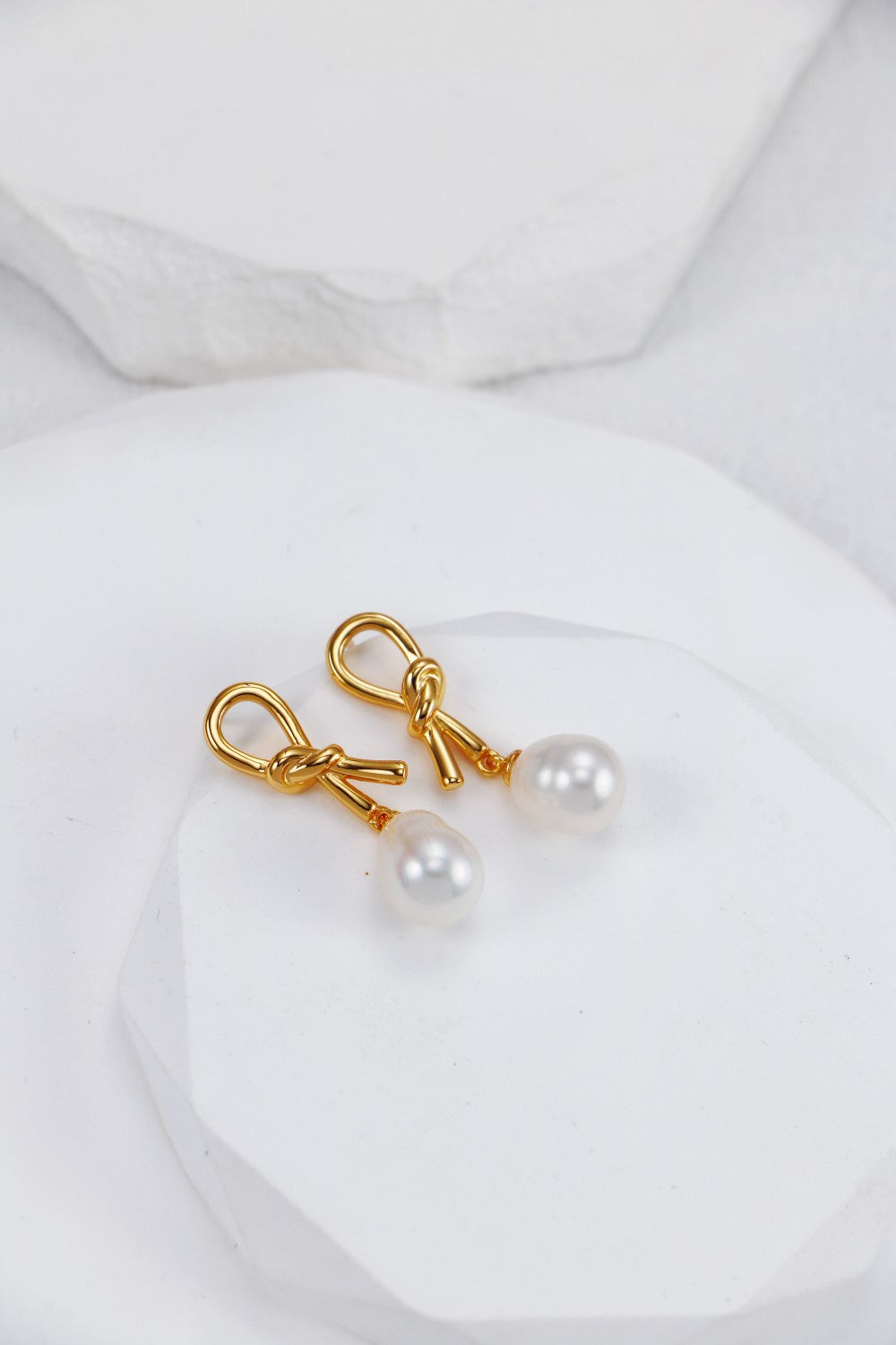 Elegant gold-plated earrings featuring lustrous white pearls, perfect for adding a touch of sophistication to any outfit.