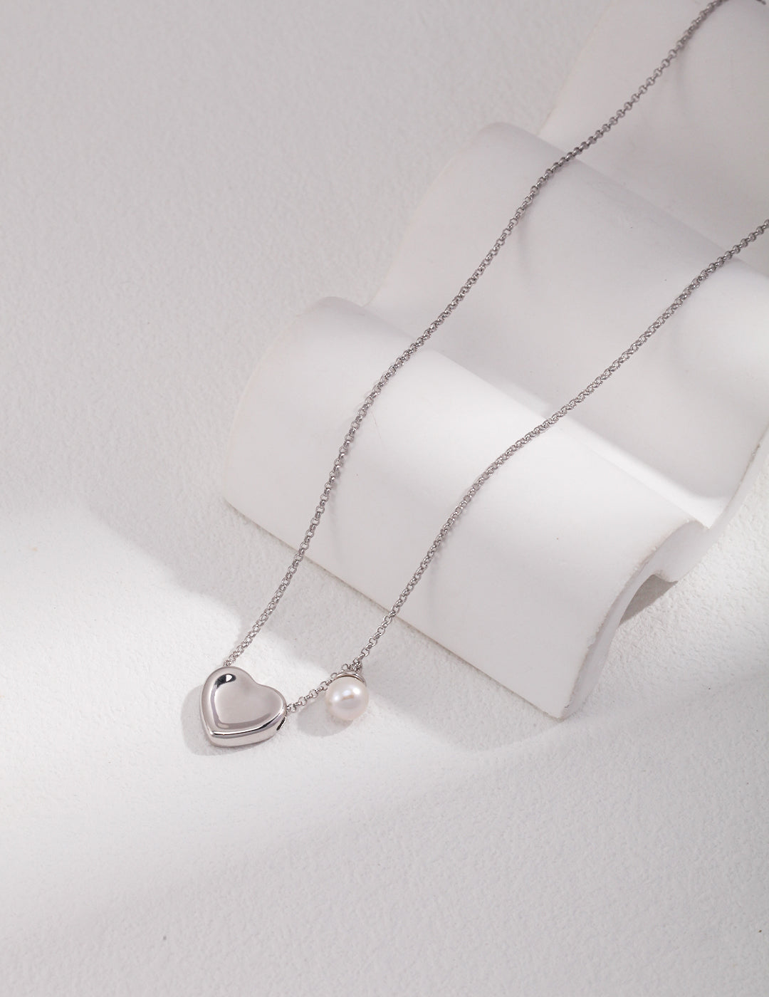 Heart pendant necklace adorned with a pearl