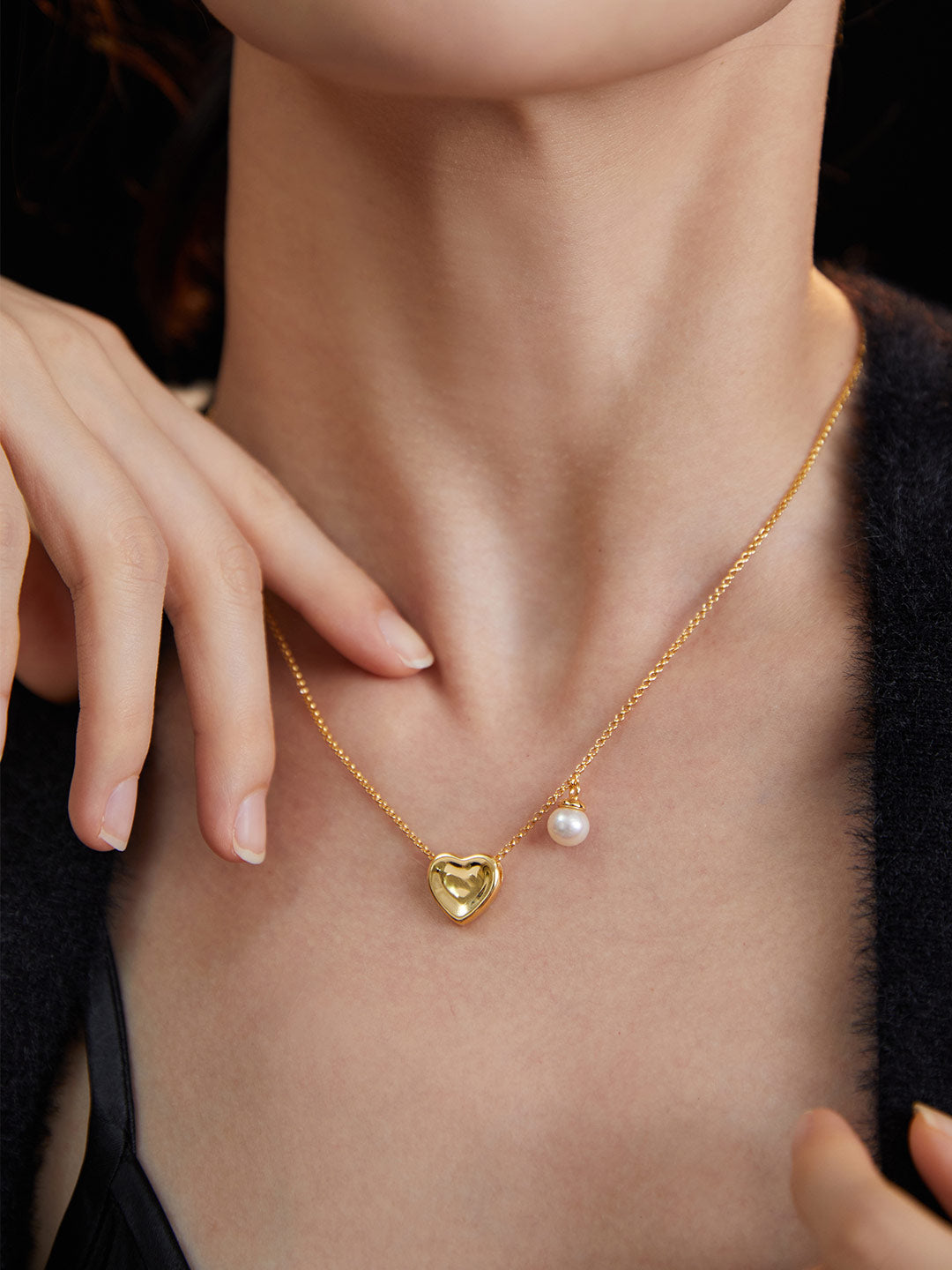 Woman in gold plated heart pendant necklace with freshwater pearl.