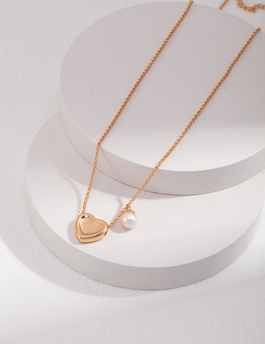 Elegant gold heart necklace featuring a single pearl