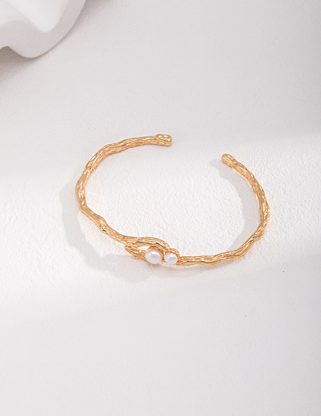 Stylish gold bangle embellished with freshwater pearls.