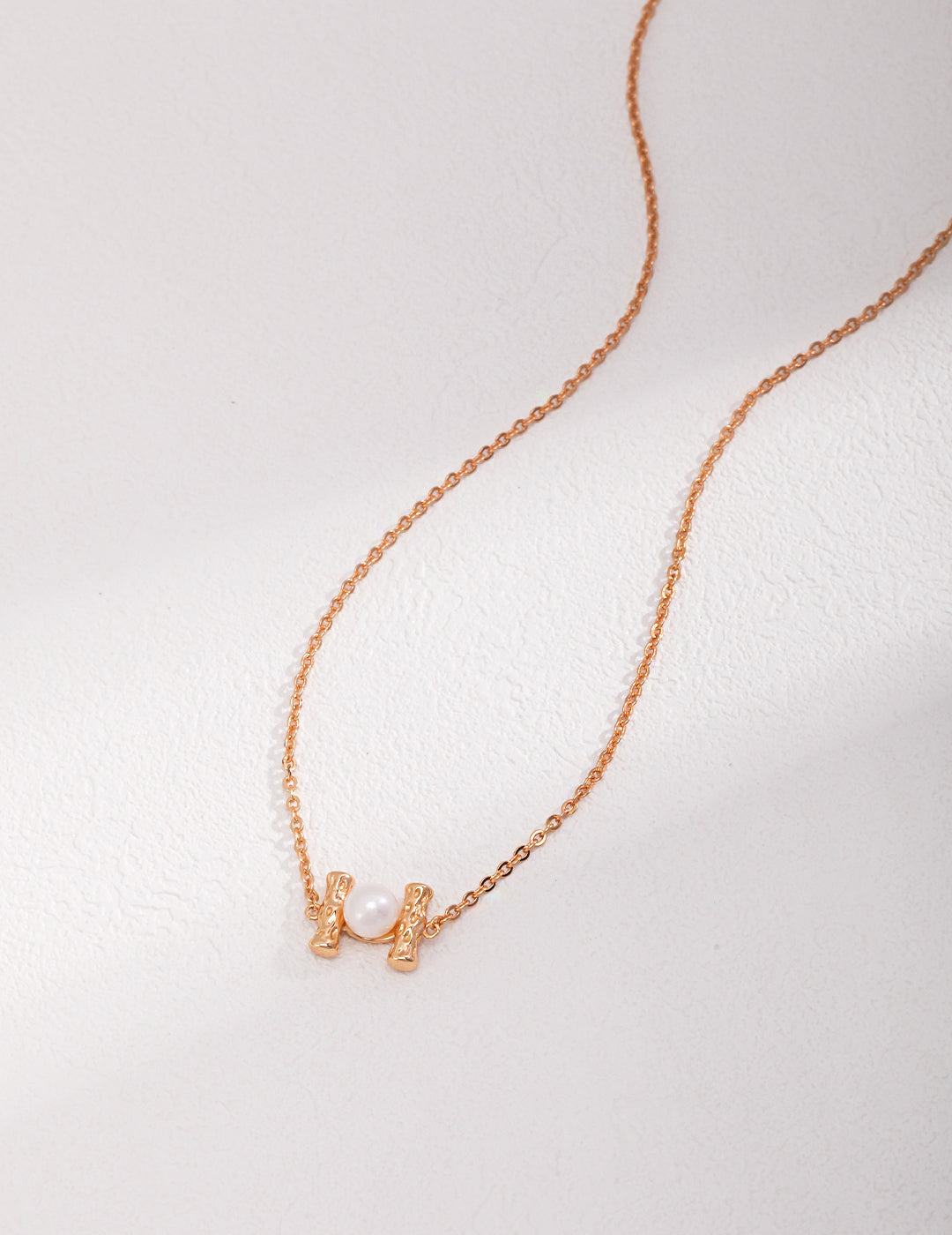 A stunning gold plated necklace adorned with a lustrous pearl, adding elegance and charm to any outfit.