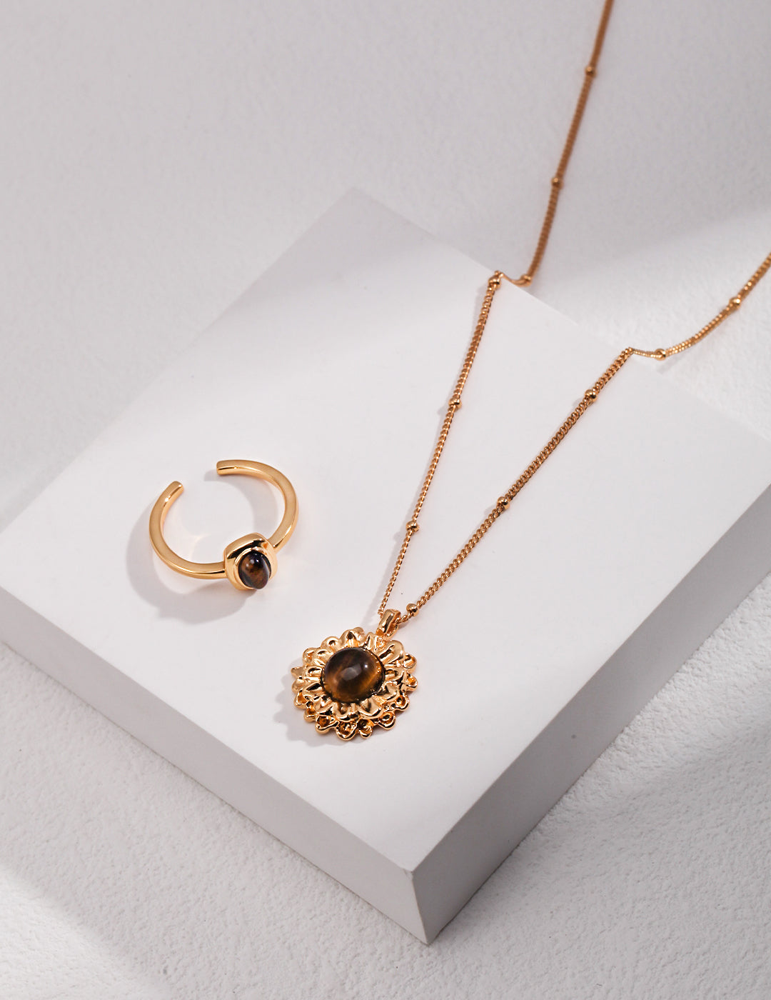 Tiger's eye gold jewelry set on a white surface.