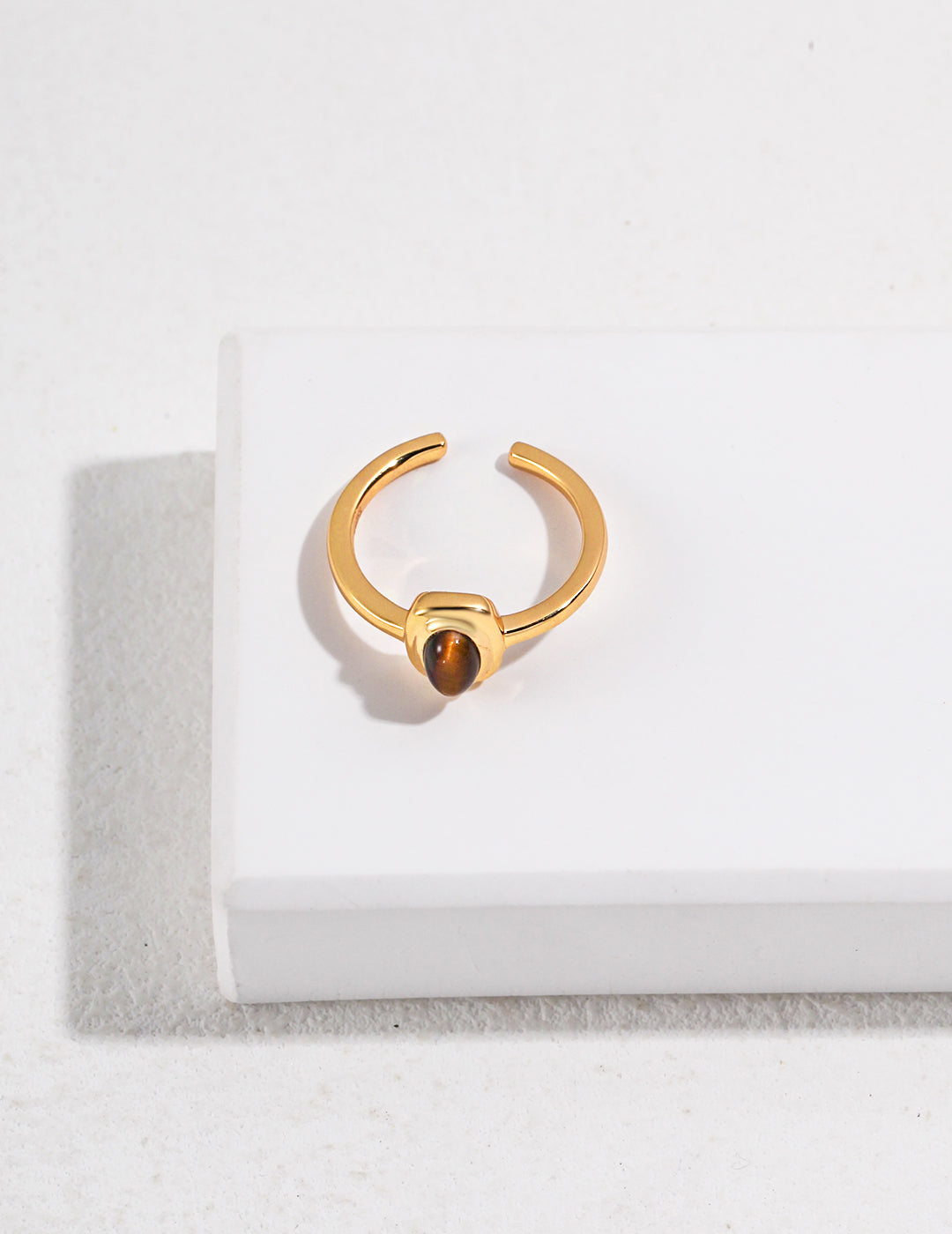 Gold ring featuring an oval-shaped tiger's eye gem.