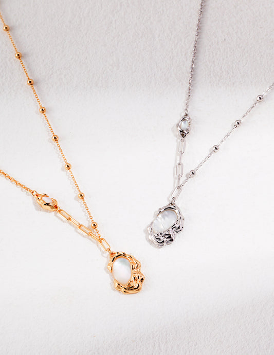 Silver and gold necklaces with mother of pearls pendants.