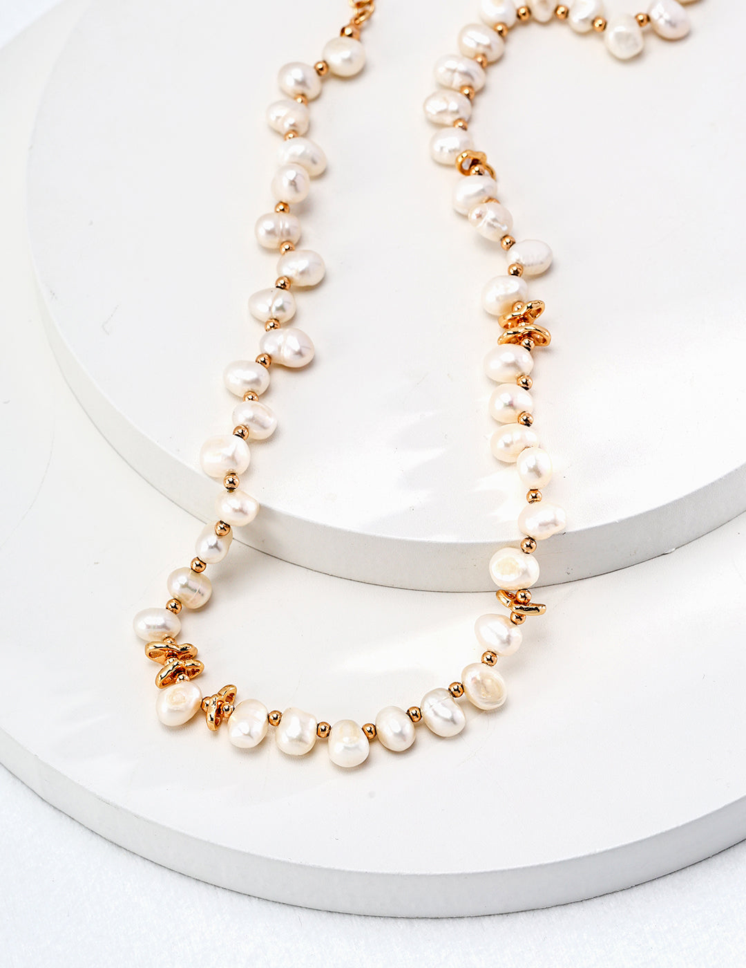 A stunning gold necklace adorned with lustrous freshwater pearls, creating an elegant and timeless accessory.