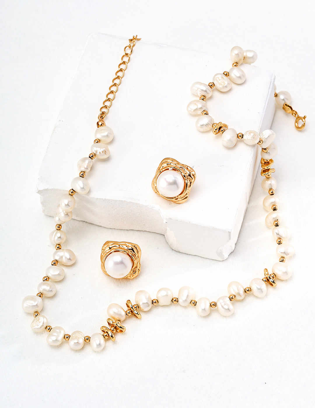 A white box with a gold chain and pearl necklace. The necklace features lustrous freshwater pearls and pairs well with matching earrings.