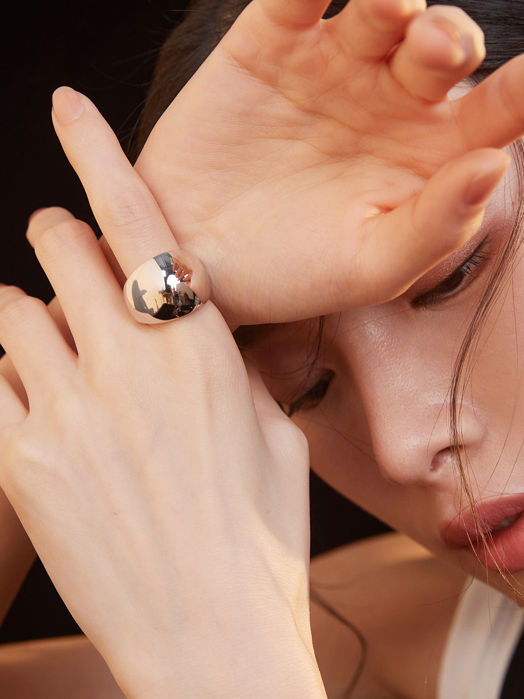 Close-up of woman's hand with silver dome ring.