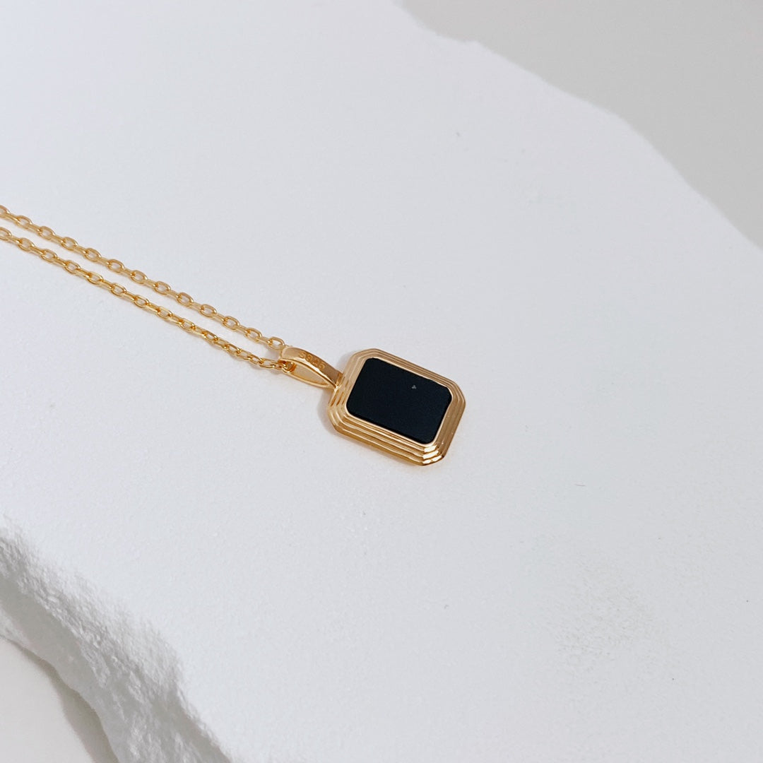 Elegant gold plated necklace showcasing a two-way pendant with black agate and shell pearl options.