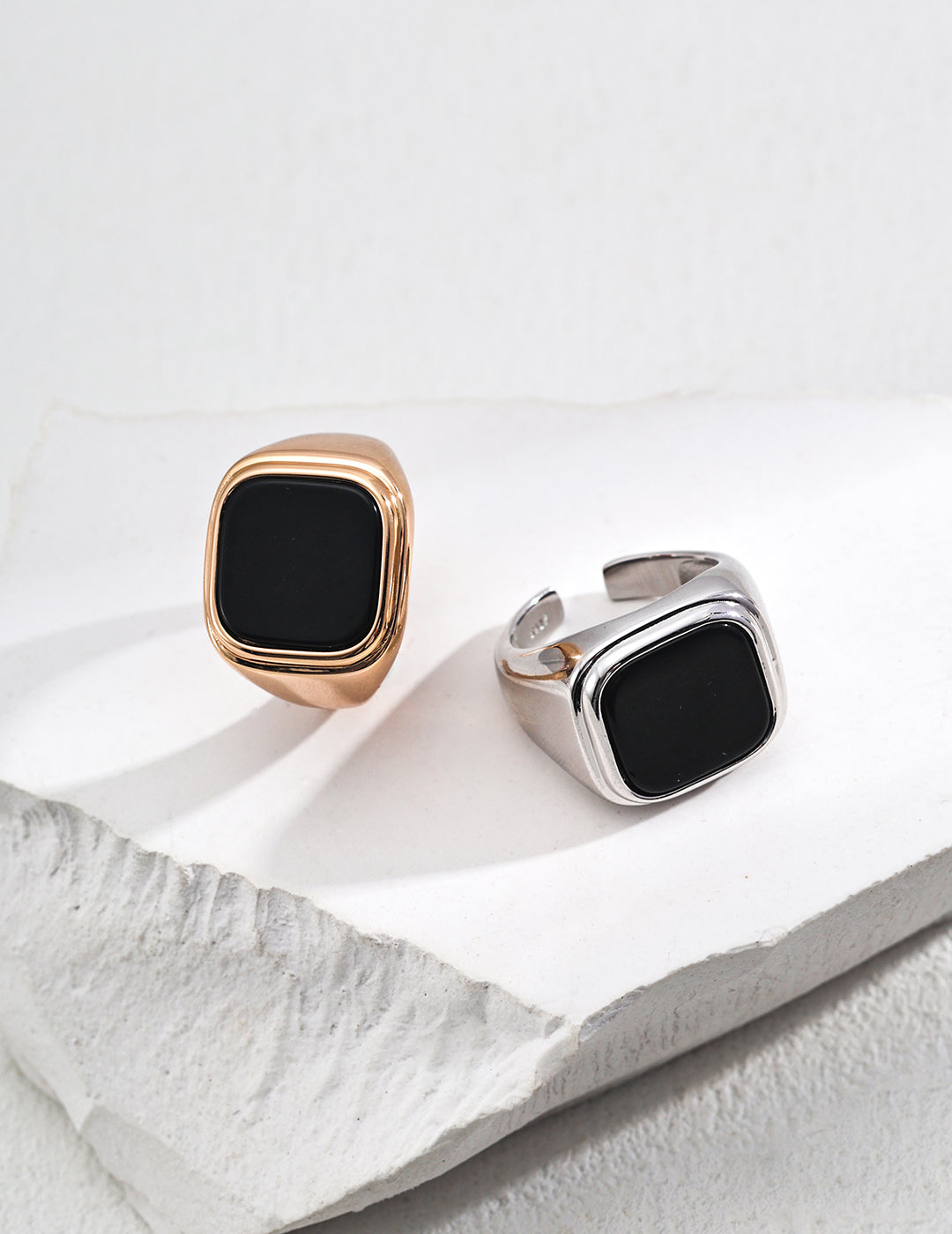 Two elegant rings featuring black onyx, showcasing a stylish design in silver and gold options.