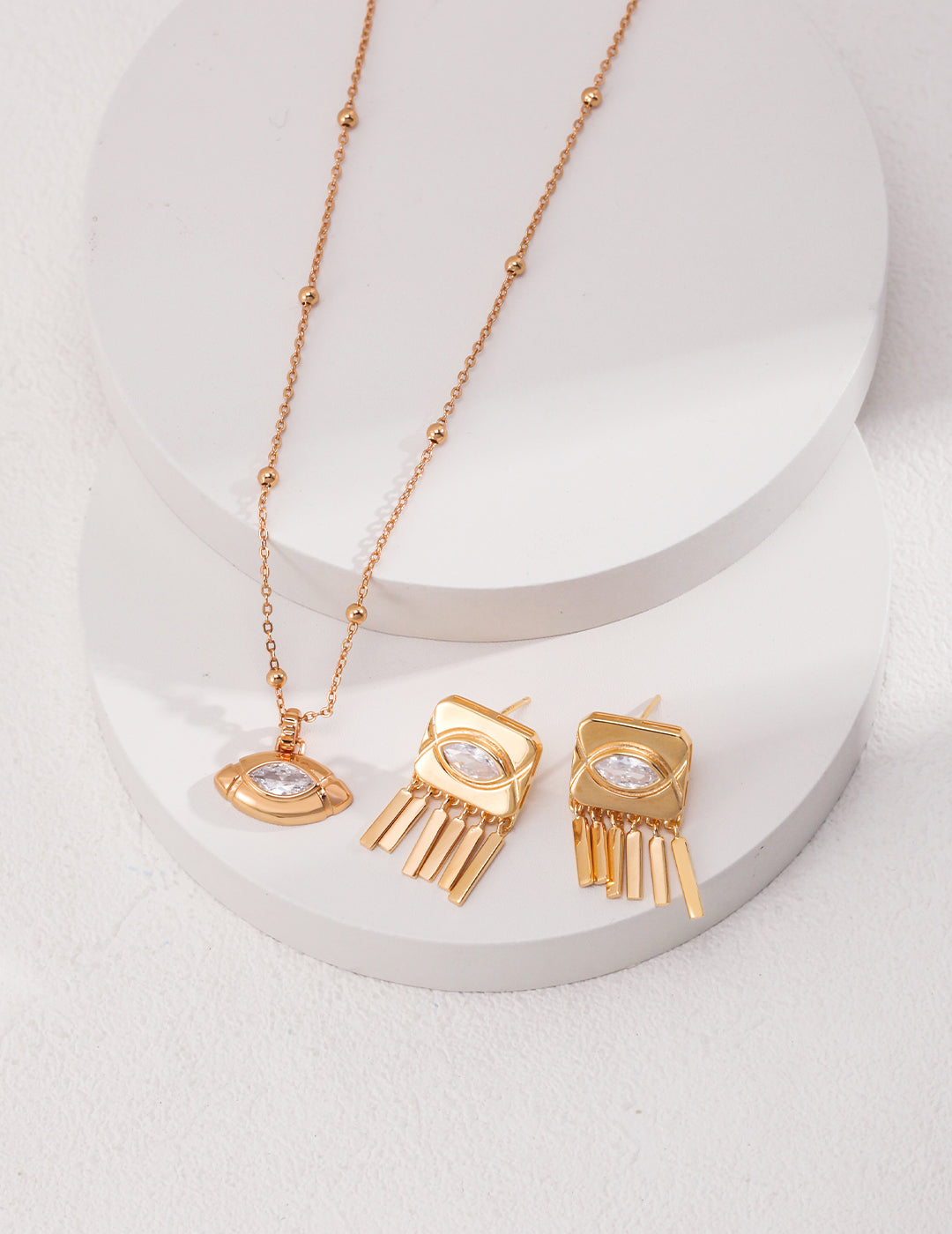 Stunning gold earrings and necklace set on a clean white surface.