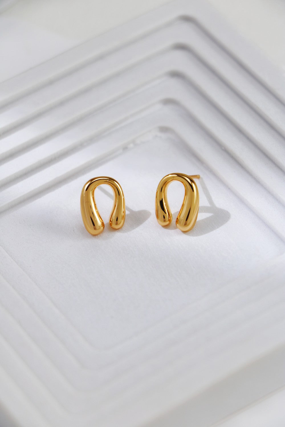 Elegant gold horseshoe earrings with a delicate small circle, perfect for adding a touch of sophistication.